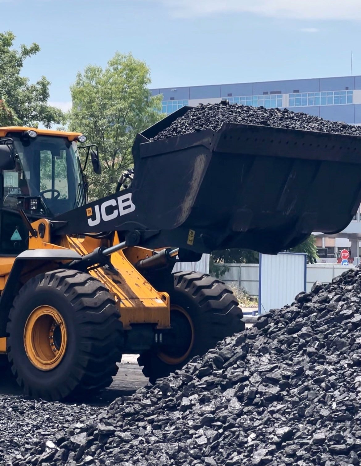 Traktor hebt und lädt hochwertige Anthrazitkohle, bereit für den Transport zur Produktionsanlage.